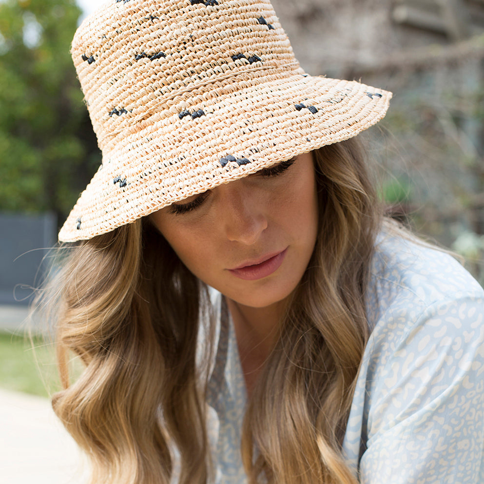Woman wearing Bravo pure raffia sun hat with graduating brim and adjustable chinstrap
