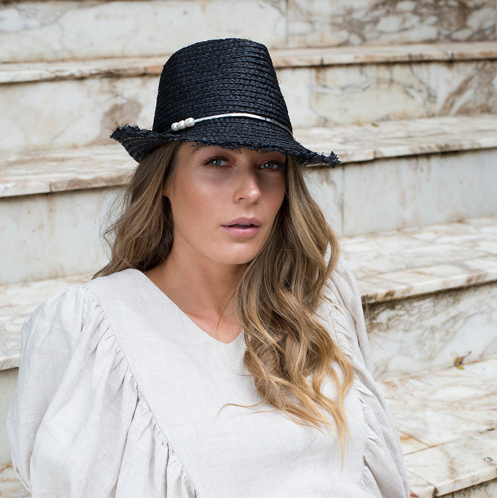 Woman wearing black raffia GIRLY PEARLY hat with freshwater pearl trim