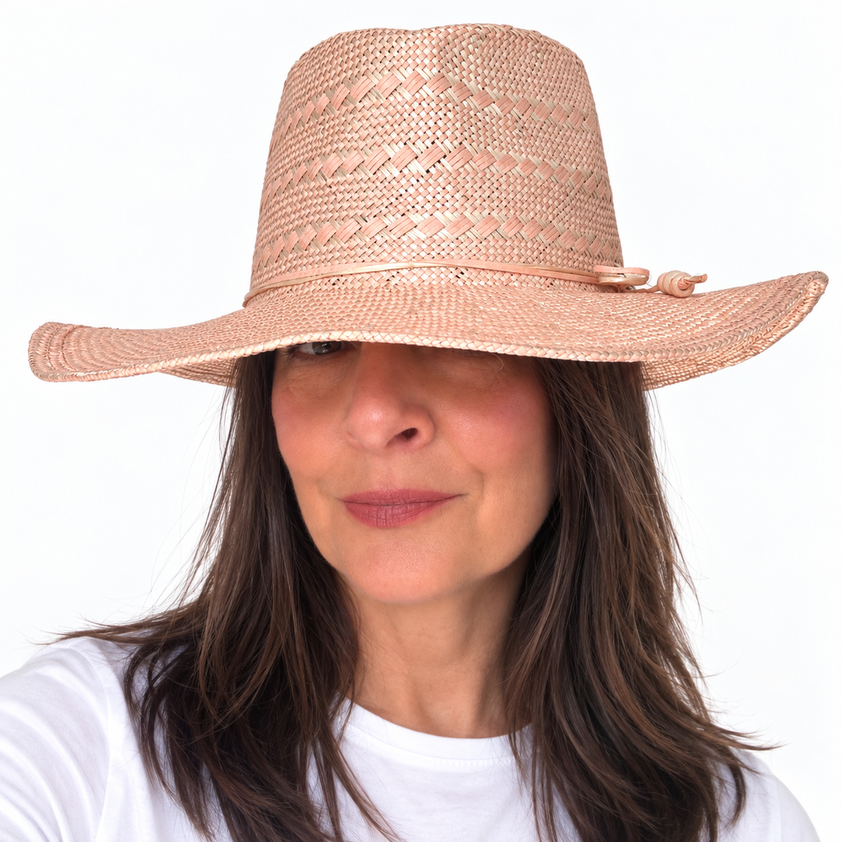 SUN-KISSED Blush woven straw hat with wide brim worn by brunette woman