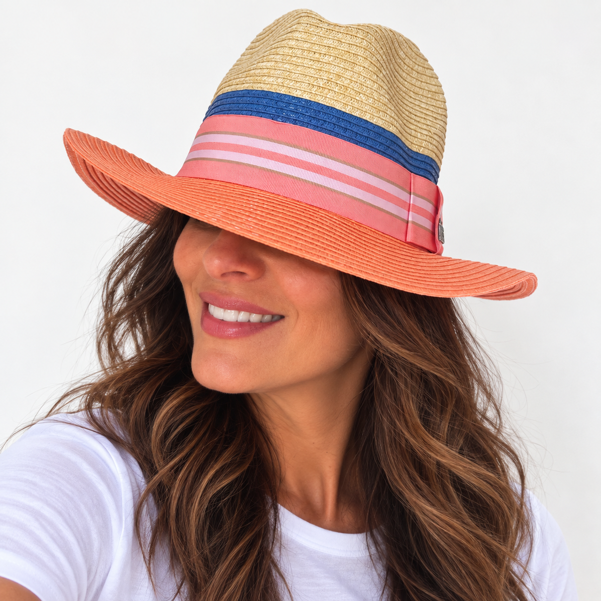 Miami Peach natural and peach paper hat with striped grosgrain ribbon worn by woman