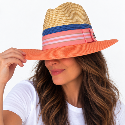 Miami Peach natural and peach paper hat with striped grosgrain ribbon worn by woman holding brim