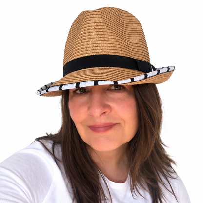 Opposites Attract tan woven hat with black band and black-and-white striped brim trim worn by brunette woman