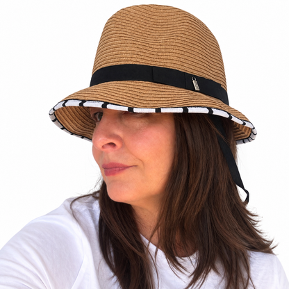 Opposites Attract tan woven hat with black band and contrasting striped brim trim on brunette woman