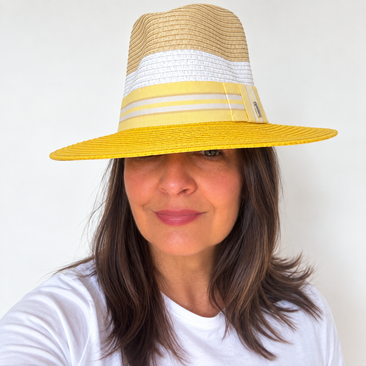Woman wearing Here Comes The Sun yellow and natural sun hat, front view