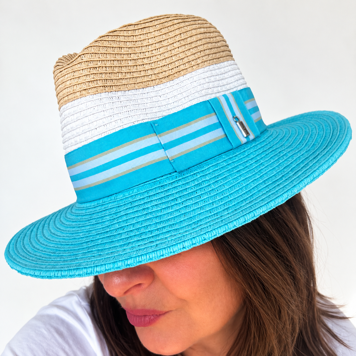 Woman wearing Dive Right In blue and natural sun hat, looking down