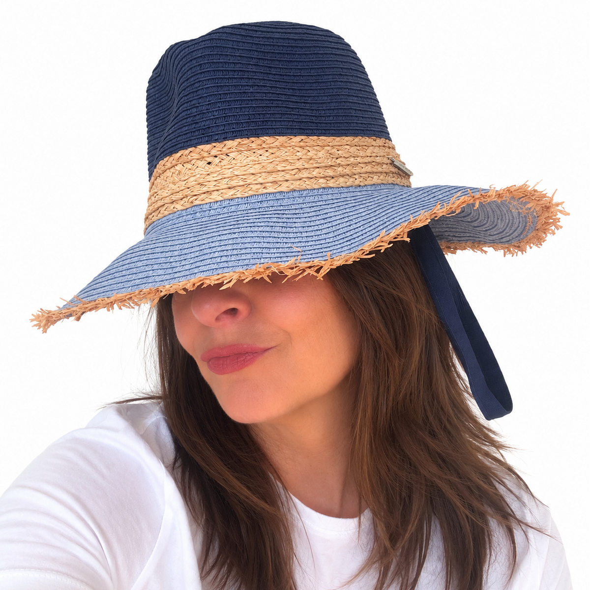 Baby Blues navy and blue woven sun hat with natural straw band worn by woman against white background
