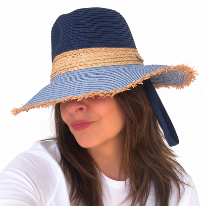 Baby Blues navy and blue woven sun hat with natural straw band worn by woman against white background
